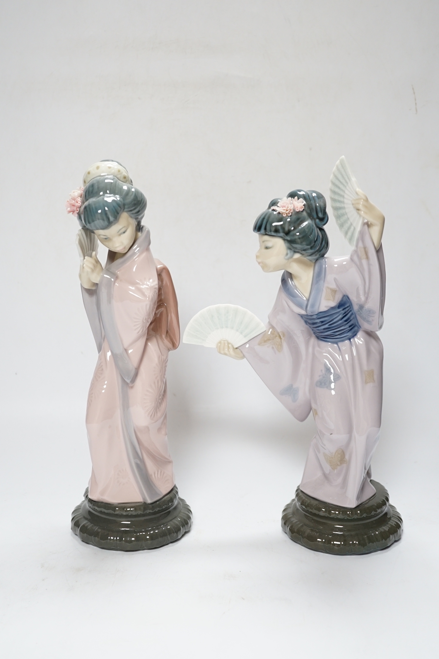 Three Lladro figures, Mirror Mirror, and two Japanese Geisha girls holding fans, (one boxed) tallest 29cm high